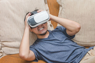 High angle view of man using mobile phone on sofa