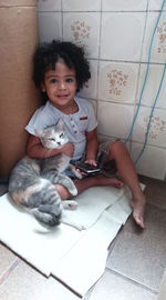 Portrait of cute baby girl on tiled floor