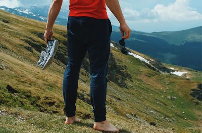 Low section of man standing on mountain road