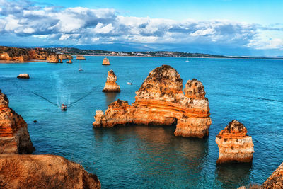 Rock formations in sea against sky