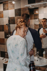 Man and woman standing in bathroom at home