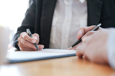 Midsection of businessman having discussion with client in office