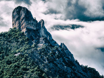 Steep mountain peak with clouds in the back in france