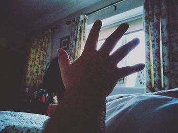 Close-up of hand touching window at home