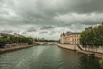 Bridge over river in city against sky