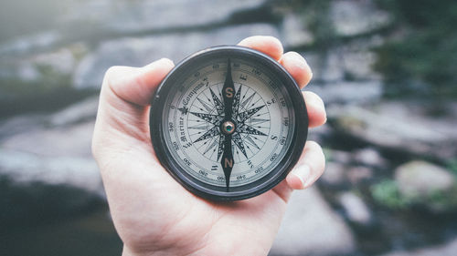 Close-up of hand holding navigational compass