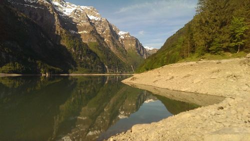 Reflection of rocky mountains in lake on sunny day