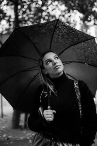 Portrait of young woman holding umbrella