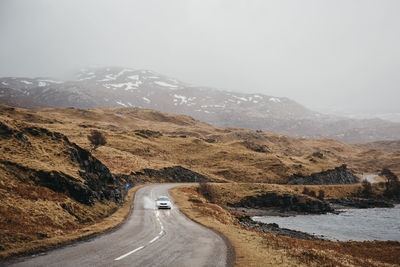 Road leading towards mountains against sky