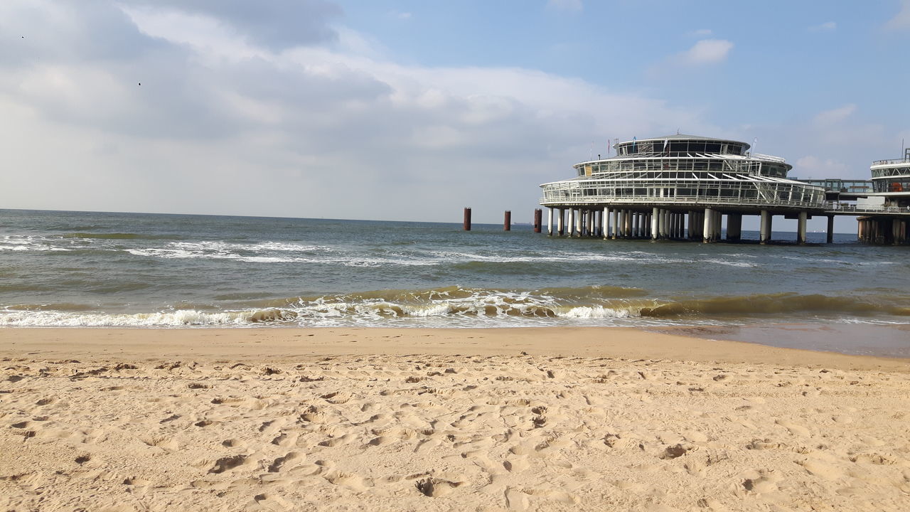 sea, beach, horizon over water, built structure, nature, architecture, sky, water, outdoors, cloud - sky, sand, building exterior, scenics, tranquil scene, day, tranquility, beauty in nature, real people