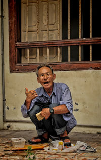 Portrait of a smiling young man sitting on floor