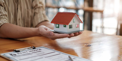 Midsection of child holding toy on table at home