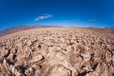 Scenic view of desert against blue sky