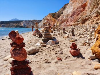 Rock formations on shore against sky