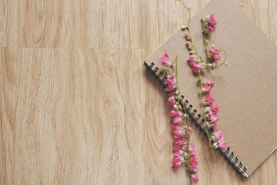 High angle view of pink flowers on wooden table