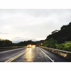 Country road against cloudy sky