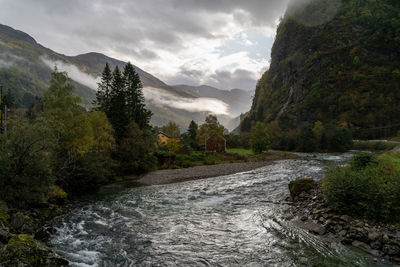 Scenic view of river amidst mountains against sky