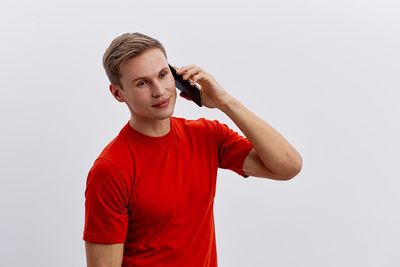 Young man standing against white background