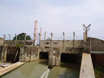 Low angle view of bridge over canal against sky