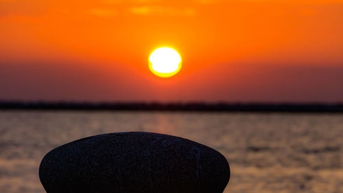 Close-up of sea against orange sky