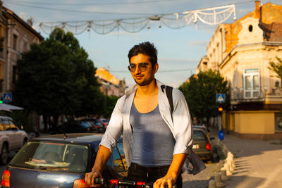 Portrait of young man standing in city