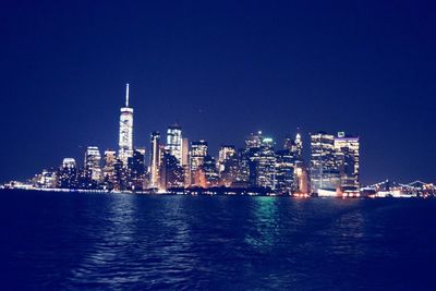 Illuminated cityscape against sky at dusk