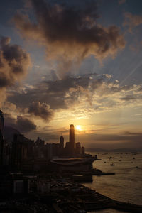 View of cityscape against cloudy sky during sunset