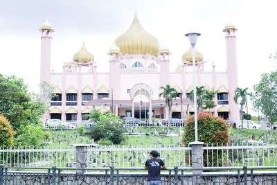 Rear view of man with woman in front of building