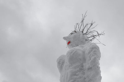 Low angle view of sculpture made on snow against sky
