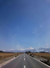 Road on landscape against blue sky