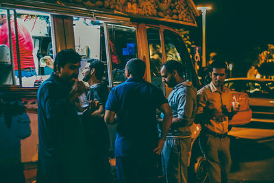 Rear view of people enjoying in city at night