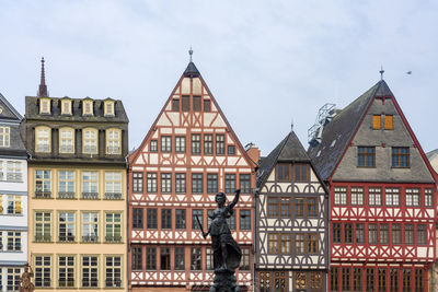 Man standing by building against sky in city