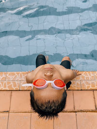 High angle view of man lying on swimming pool