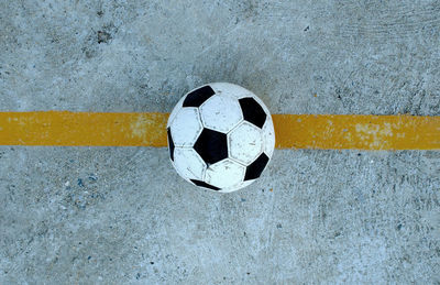 Directly above shot of soccer ball on concrete