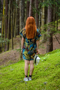 Full length rear view of a man walking in forest
