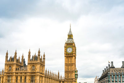 Low angle view of big ben in city against cloudy sky