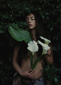 Beautiful young woman standing by leaves