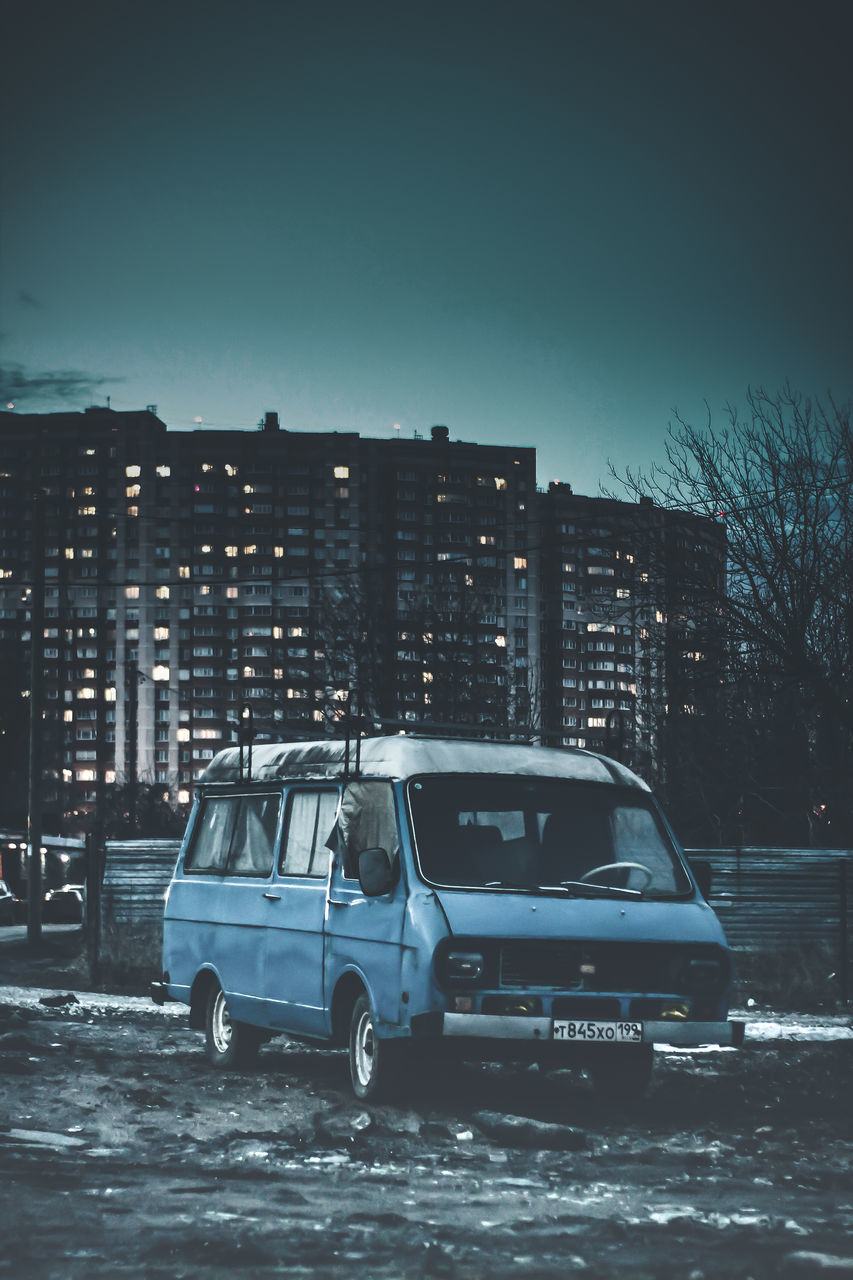 CARS ON STREET AGAINST BUILDINGS DURING WINTER