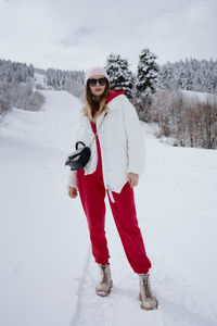 Full length of woman skiing on snow covered field