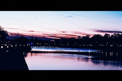 Reflection of illuminated buildings in water at dusk