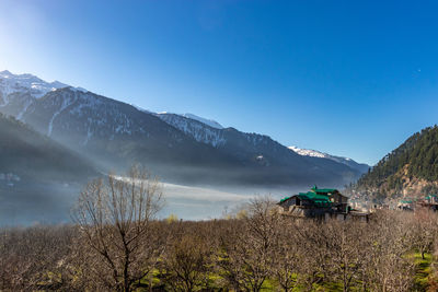 Scenic view of mountains against clear blue sky