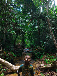 Portrait of young man standing in forest