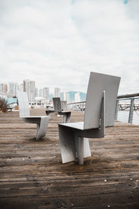 Tables and chairs against sky in city