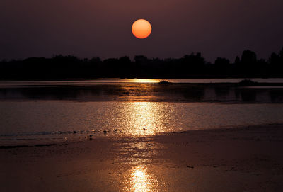 Scenic view of lake against orange sky