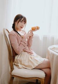 Young woman sitting on sofa at home
