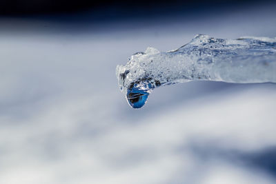 Close-up of snow covered mountain against cloudy sky