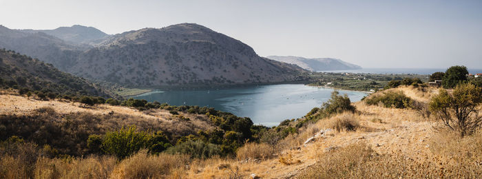 Scenic view of sea and mountains against clear sky