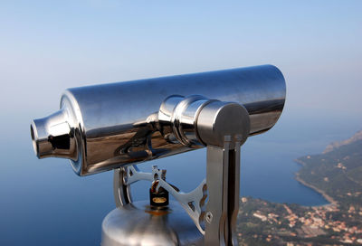 Close-up of coin-operated binoculars against sky