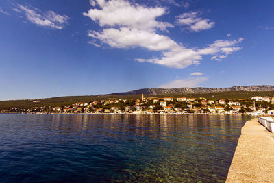 Scenic view of lake against sky in city