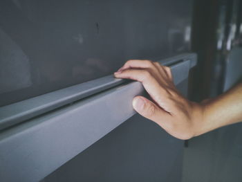 Cropped hand of woman opening refrigerator